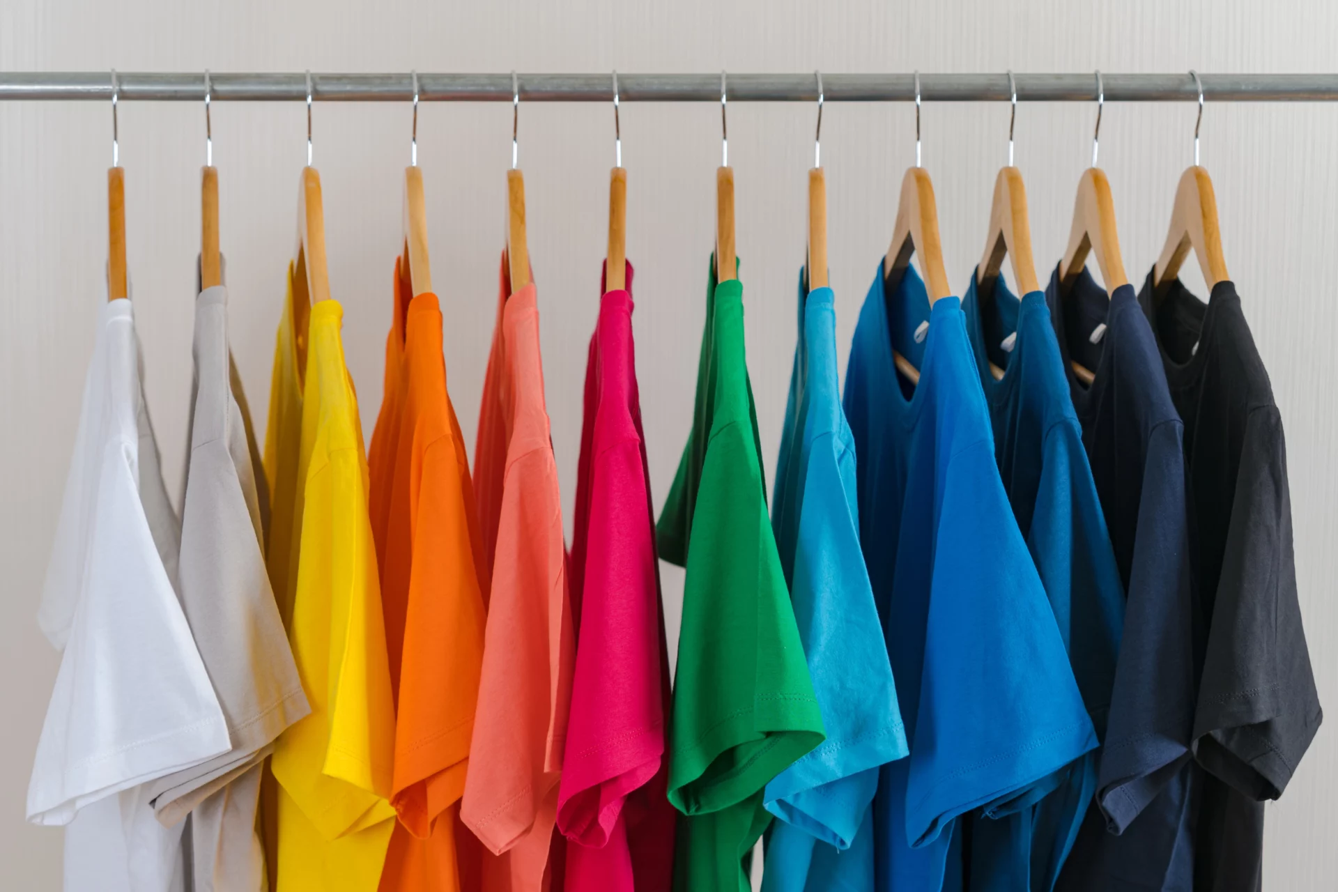 atelier-brod-art-creations-soissons-aisne-marquage-textile-tee-shirts-personnalises-couleurs-articles-blog-grammage-textile T-shirts personnalisés de différentes couleurs suspendus sur cintres – choix de textiles pour impression ou broderie, proposés par Atelier Brod’Art Créations à Soissons
