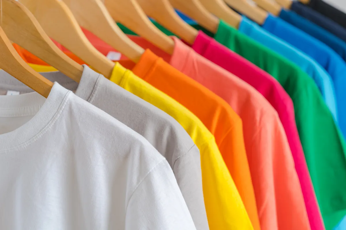T-shirts unis de différentes couleurs suspendus – Supports textiles à personnaliser chez Atelier Brod’Art Créations à Soissons.